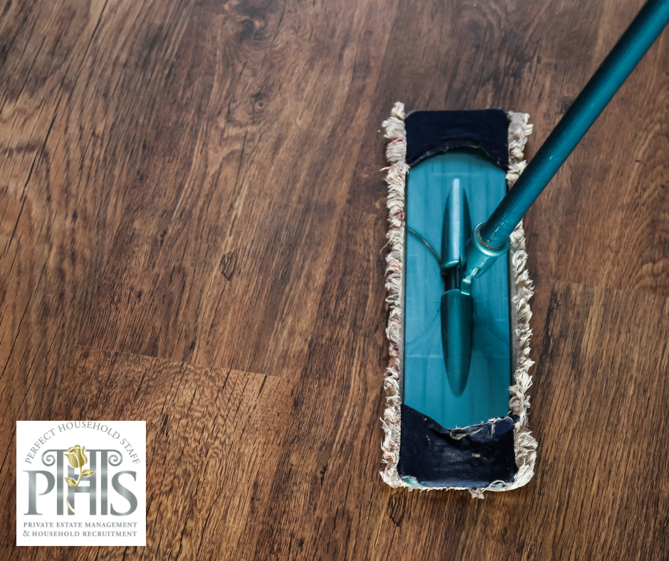 Gently cleaning a hardwood floor with a microfibre mop, following expert wood surface maintenance tips.